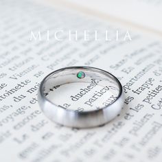 a close up of a wedding ring on top of an open book with the word, michael