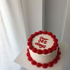 a white cake with red icing and the words 60 years on it sitting on top of a table