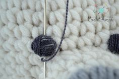 a close up view of a crocheted blanket with two balls of yarn on it