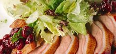 meat with cranberry sauce and lettuce on white plate