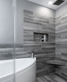 a white bath tub sitting next to a walk in shower