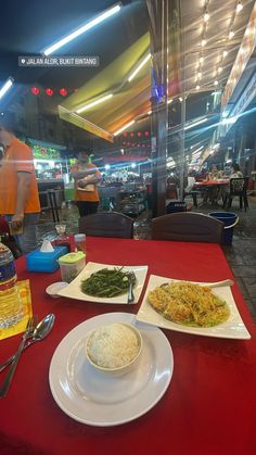 two plates of food are sitting on a red table