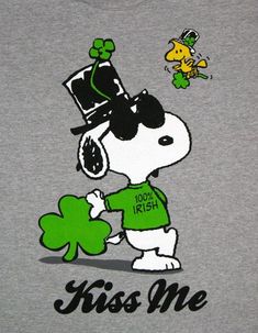 a snoopy dog wearing sunglasses and a hat holding a shamrock with the words kiss me on it