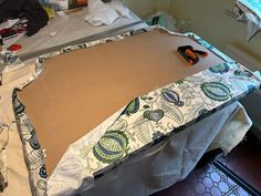 the table is being prepared to be made with paper and fabric, including some scissors