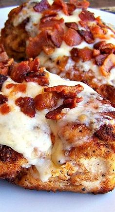 two pieces of pizza covered in bacon on a plate