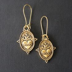 "Gold Sacred Heart dangle earrings. These delightful gold heart and crown earrings will add a touch of peacefulness knowing that Jesus loves mankind. The detailed dainty heart charms are rich in details. Ear wires are gold plated. Extremely light weight and comfortable to wear, 2.00\"x .75\". These Mystic Pieces delights will offer years of serenity in the love of Jesus Christ. The devotion to the Sacred Heart (also known as the Most Sacred Heart of Jesus , Sacratissimum Cor Iesu in Latin) is on Catholic Earrings, Frida Earrings, Jewelry Gold Earrings, Crown Earrings, Catholic Jewelry, Estilo Boho Chic, Earrings Heart, Heart Dangle Earrings, Jewelry Earring