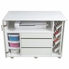 a white cabinet with two drawers and some paint cans on it's sides,