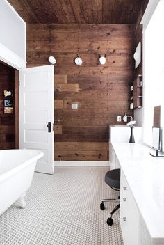 a white bath tub sitting next to a wooden wall