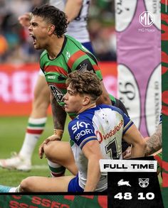 a rugby player is sitting on the ground with his mouth open as he holds onto another player's knee