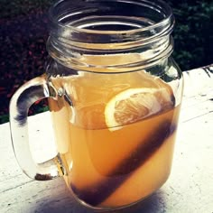 a mason jar filled with lemonade sitting on top of a wooden table