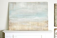 an abstract painting hangs above a fireplace mantel