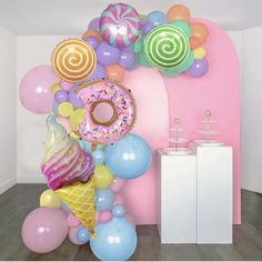 an ice cream cone, doughnuts and balloons are on display in a room