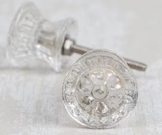 a pair of clear glass knobs sitting on top of a white table