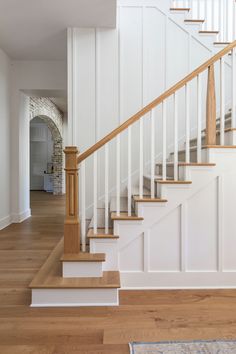 a white staircase with wooden handrails in a home