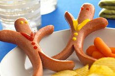 two hot dogs are made to look like people holding hands with carrots on the side