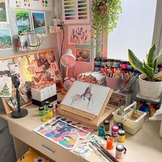 an artist's desk with lots of art supplies