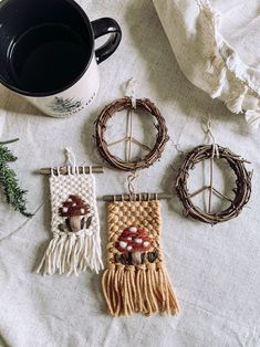 three pieces of woven art sitting next to a cup of coffee