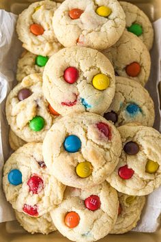 white chocolate m & m cookies in a cardboard box with candy candies on top