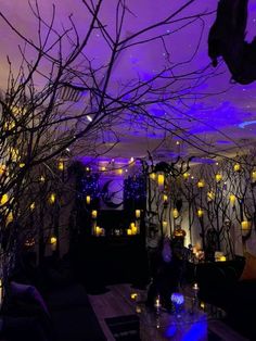 a room filled with lots of lit candles and trees in the middle of it at night