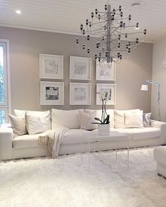 a living room filled with furniture and a chandelier hanging from the ceiling in front of a window