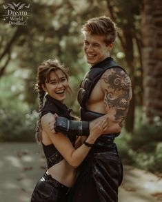 a man and woman dressed in leathers hugging each other with tattoos on their arms