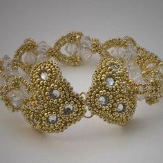 a gold bracelet with clear beads and crystal stones on the clasp is shown in front of a white background