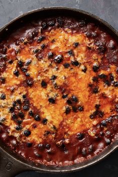 a skillet filled with cheese and black olives