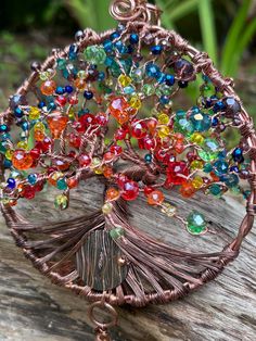 the tree of life pendant is made from wire and glass beaded with multicolored beads