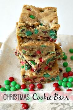 christmas cookie bars stacked on top of each other with candy candies scattered around them