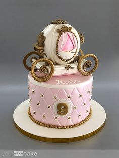 a pink and white cake with gold trimmings is on top of a plate