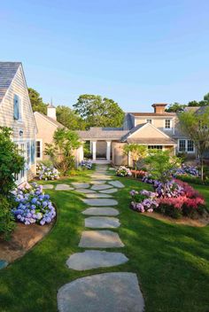 a stone path in the middle of a lush green yard