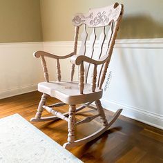 a wooden rocking chair sitting on top of a hard wood floor next to a white rug