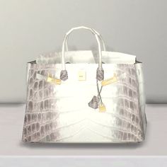 an image of a white handbag with gold accents on the handles and sides, sitting on a table