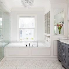 a bathroom with a tub, sink, and shower stall in it's center