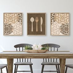 a dining room table with chairs and two paintings on the wall above it that have utensils in them