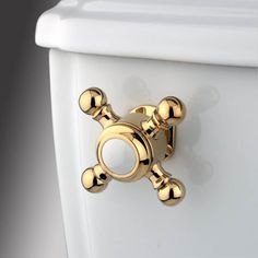 a close up of a toilet with gold knobs