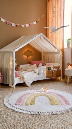 a child's bedroom with a tent bed and rug