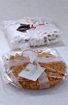 two packages of food wrapped in plastic on top of a white tablecloth covered table