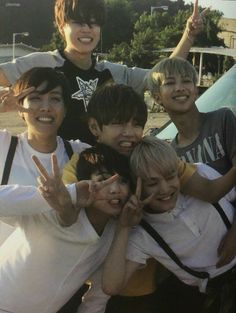 a group of young men standing next to each other with their hands in the air