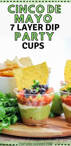 cinco de mayo 7 layer dip party cups on a cutting board with tortilla chips