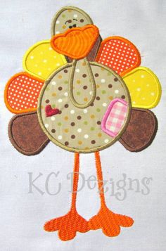 a turkey applique is shown on a white shirt with orange and pink accents