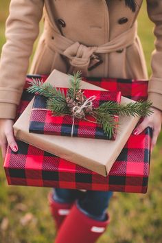 a person holding a wrapped present in front of two pictures with deer head on them