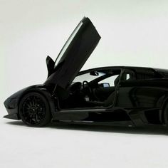 a black sports car with its doors open on a white background in front of the camera