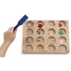 a person holding a blue toothbrush in front of a wooden box with various items inside