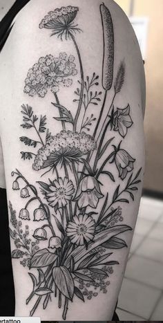 a black and white flower tattoo on the right arm, with flowers in blooming bouquets