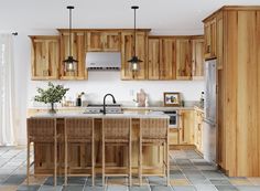 a large kitchen with wooden cabinets and an island in the middle, surrounded by tile flooring