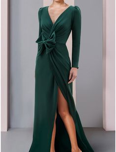 a woman in a long green dress with a slit