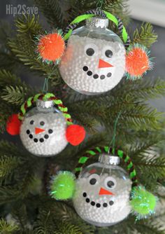 three snowman ornaments hanging from a christmas tree