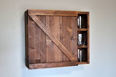 a sliding barn door is mounted on the wall with glass jars and shot glasses in it