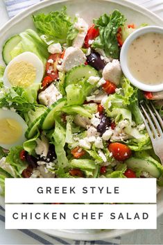 greek style chicken chef salad on a white plate with a fork and bowl of dressing